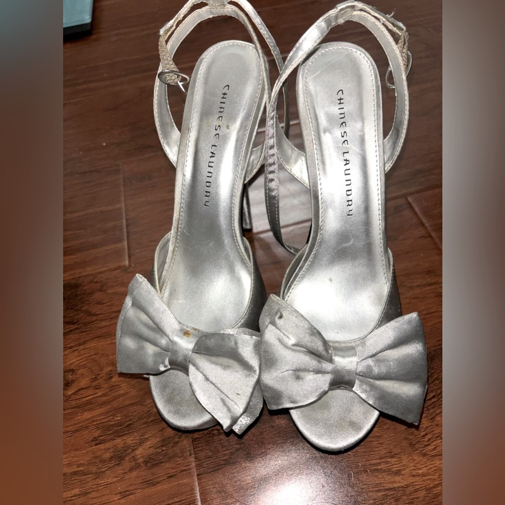 Cute Chinese Laundry silver heels with bow on the toe.